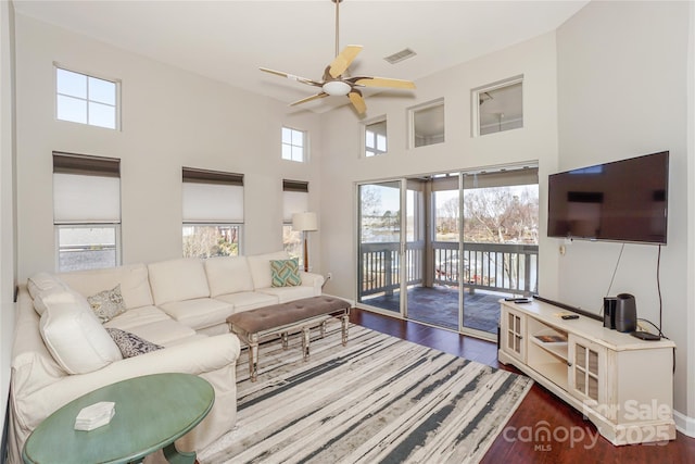 living room featuring a healthy amount of sunlight, visible vents, and dark wood finished floors