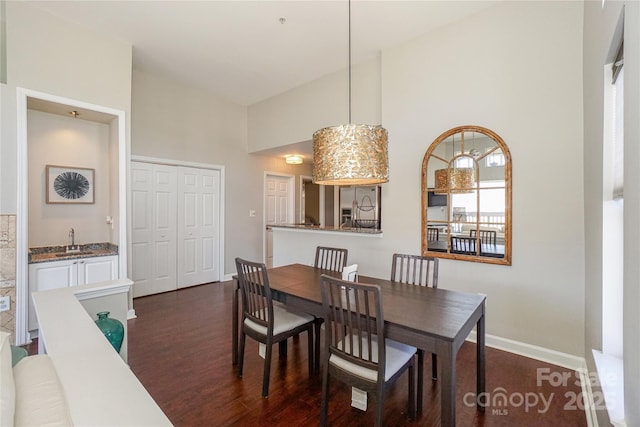 dining area with baseboards, high vaulted ceiling, and dark wood-type flooring