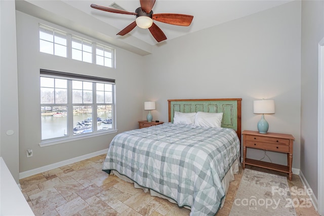 bedroom with a ceiling fan, stone finish flooring, visible vents, and baseboards