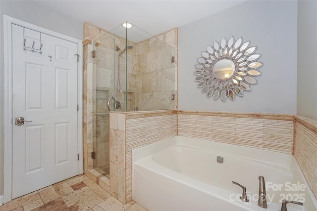 full bath featuring a stall shower and a garden tub