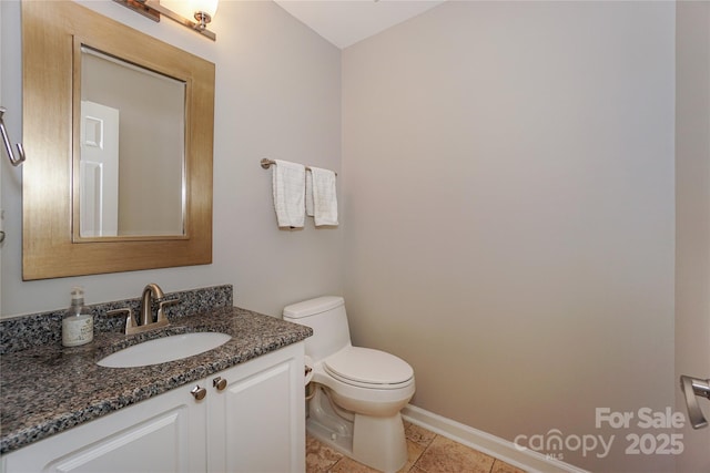 bathroom with tile patterned flooring, baseboards, vanity, and toilet