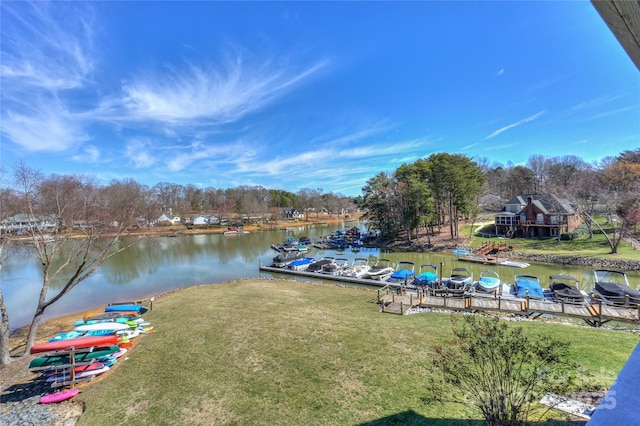 dock area with a water view and a yard