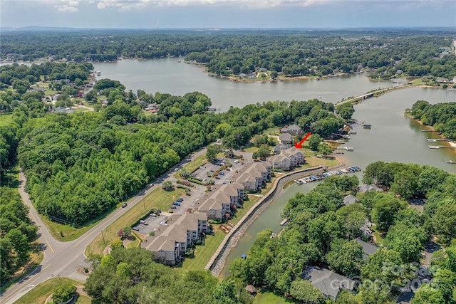 aerial view with a water view and a forest view