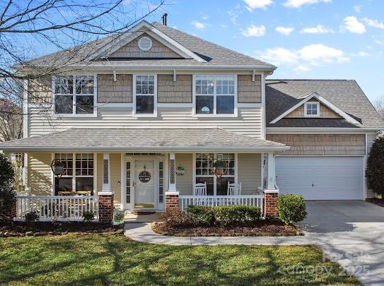 craftsman inspired home with a porch, an attached garage, and driveway