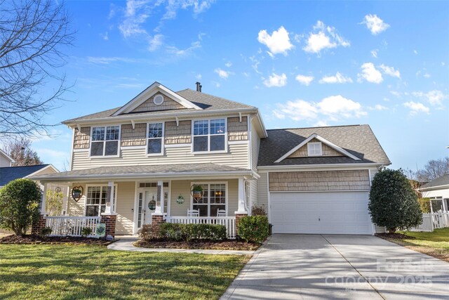 view of front of home featuring a porch, a front yard, driveway, and a garage