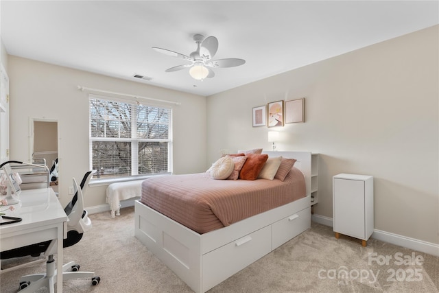 bedroom featuring visible vents, light colored carpet, a ceiling fan, and baseboards