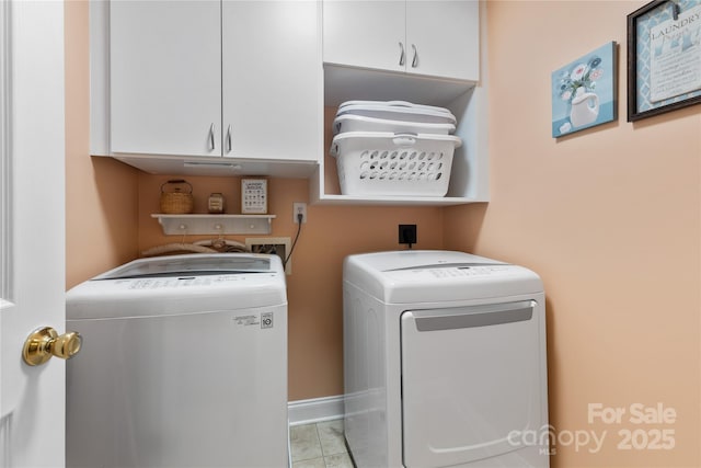 clothes washing area featuring washing machine and clothes dryer and cabinet space