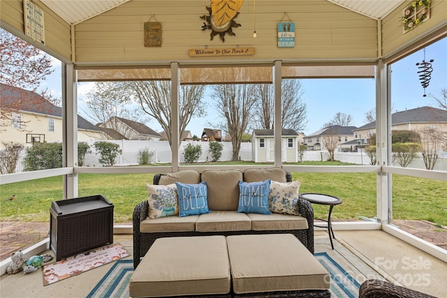 sunroom with a residential view and lofted ceiling