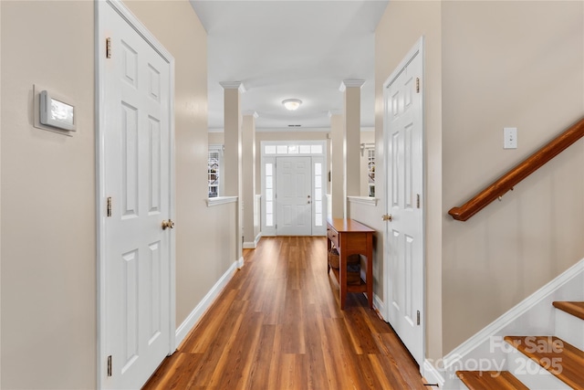 interior space with ornate columns, stairs, baseboards, and wood finished floors