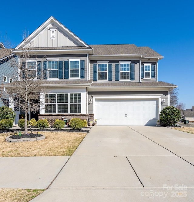 view of front of house featuring brick siding, driveway, an attached garage, and board and batten siding