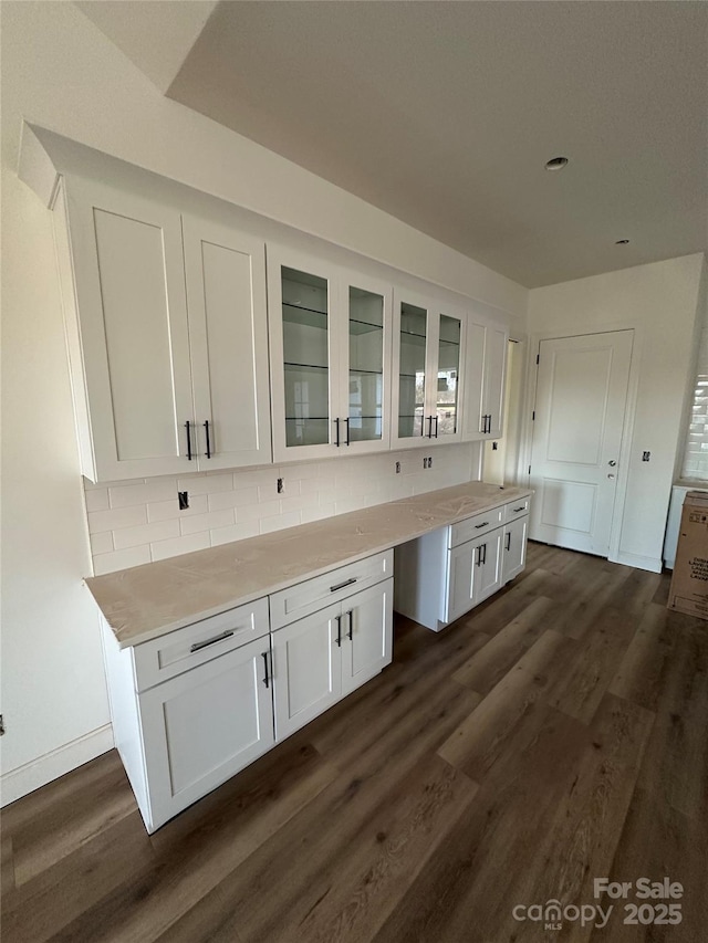 kitchen with glass insert cabinets, light countertops, dark wood-style floors, and white cabinetry