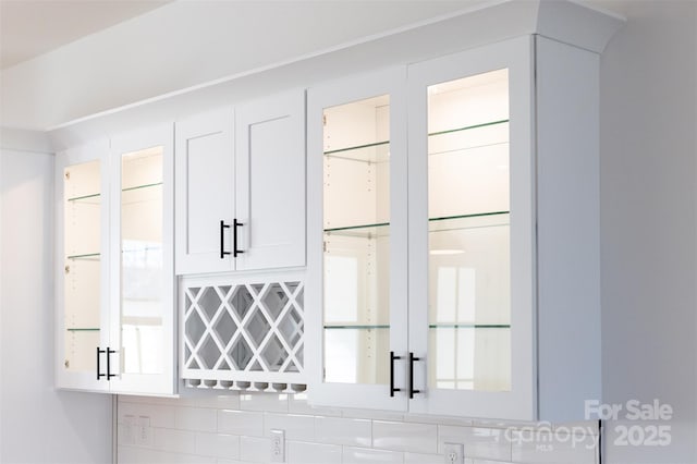 interior space featuring white cabinetry, light countertops, and backsplash