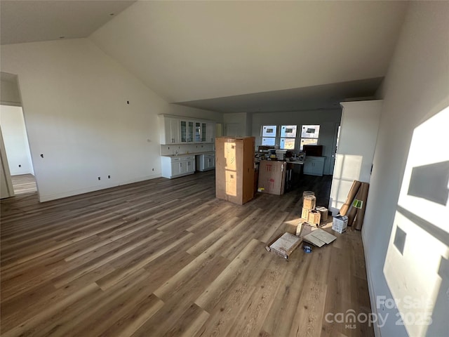 unfurnished living room featuring high vaulted ceiling and wood finished floors