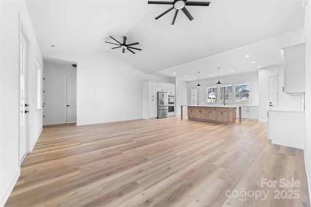 unfurnished living room featuring light wood finished floors, lofted ceiling, recessed lighting, a ceiling fan, and baseboards