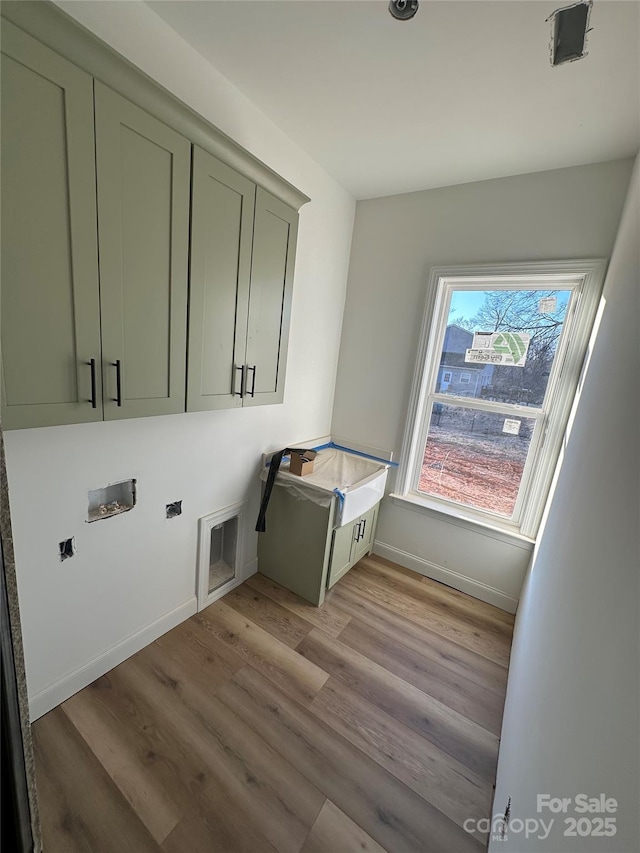 washroom featuring hookup for a washing machine, baseboards, light wood-type flooring, cabinet space, and electric dryer hookup