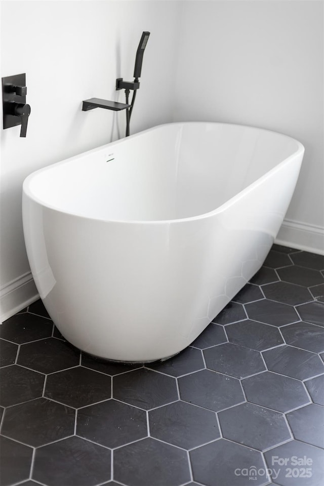 interior details with a freestanding tub and baseboards