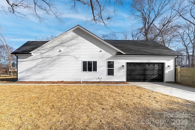 view of property exterior with driveway, a yard, an attached garage, and a shingled roof