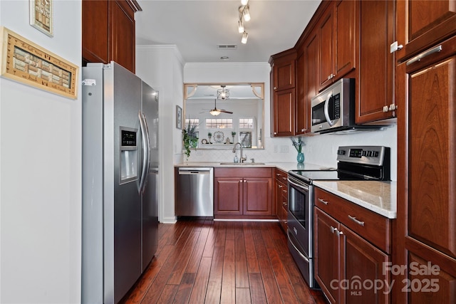 kitchen with visible vents, appliances with stainless steel finishes, a sink, crown molding, and backsplash