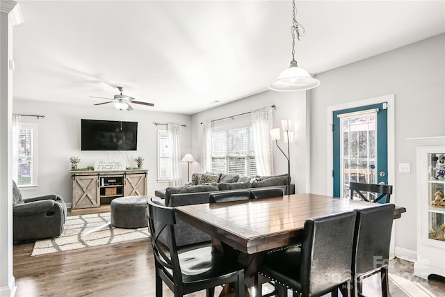 dining area with a ceiling fan, baseboards, and wood finished floors