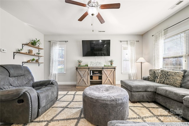 living room featuring light wood finished floors, visible vents, and a wealth of natural light