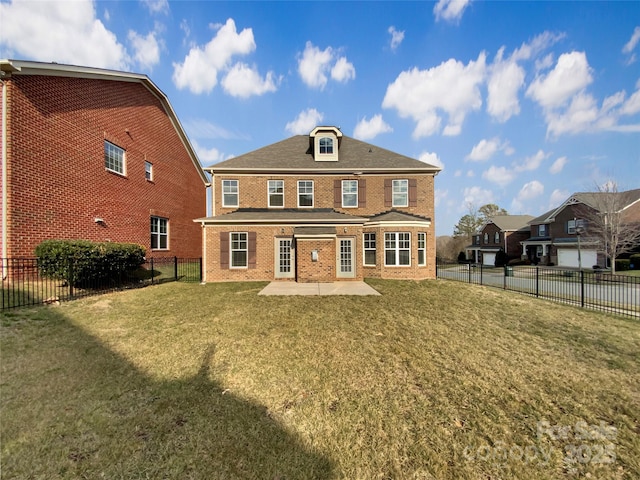 rear view of house featuring a patio area, a fenced backyard, a yard, and brick siding