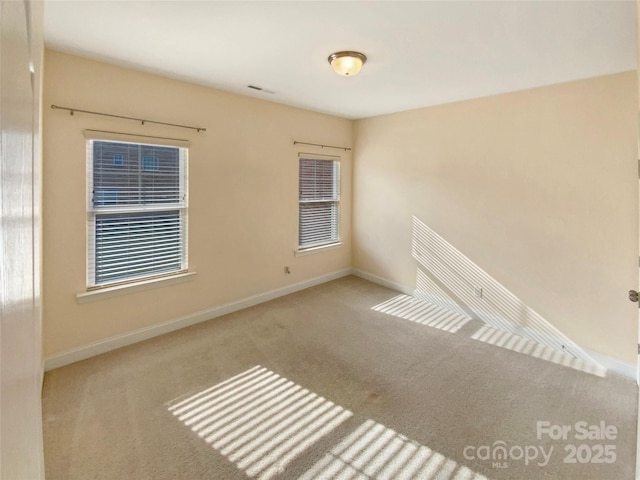 carpeted spare room with baseboards