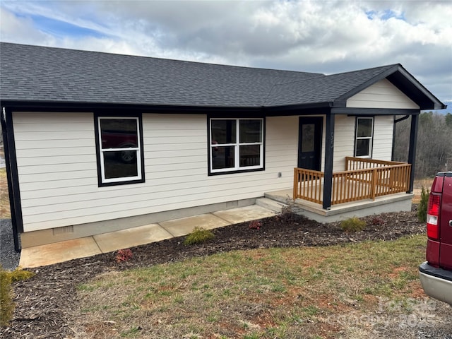 ranch-style house with roof with shingles, a porch, crawl space, and a front lawn