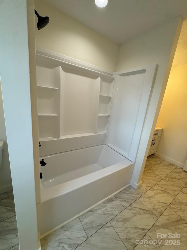 full bath featuring  shower combination, marble finish floor, and baseboards