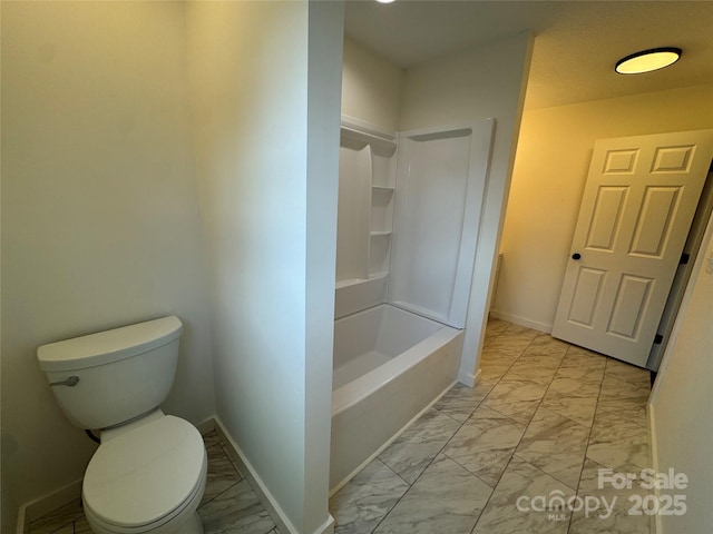 full bathroom with toilet, marble finish floor, washtub / shower combination, and baseboards