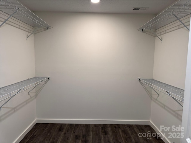 spacious closet with visible vents and dark wood-style flooring