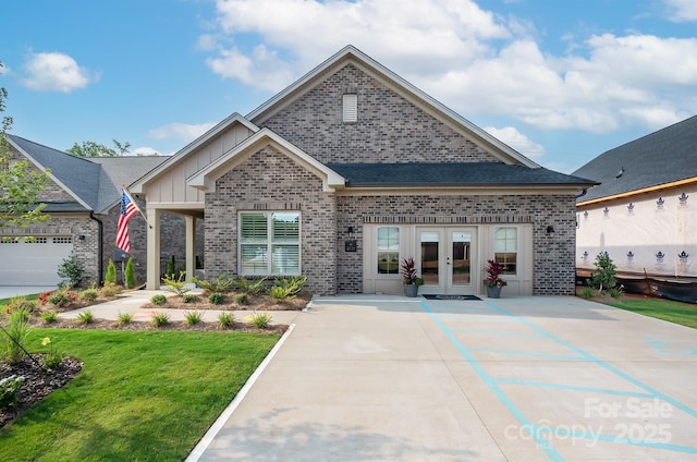 view of front of house with board and batten siding, french doors, brick siding, and a front lawn