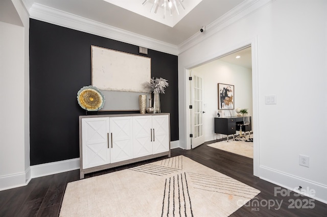 foyer with ornamental molding, baseboards, and wood finished floors