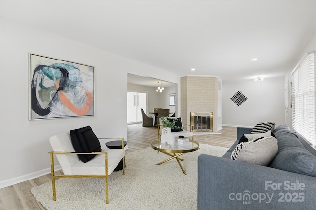 living area with baseboards, wood finished floors, recessed lighting, and a notable chandelier