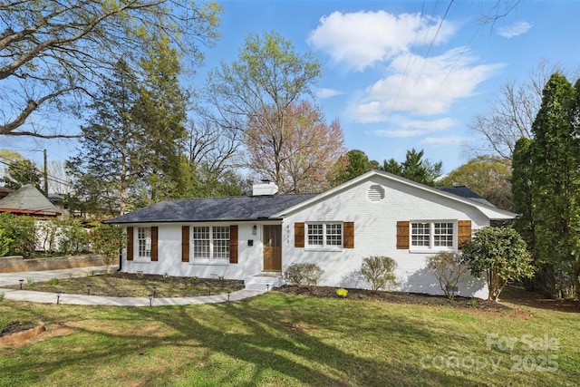 single story home featuring a chimney and a front yard