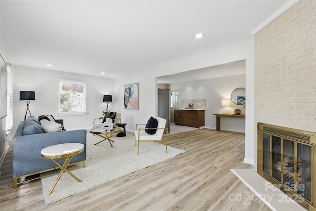living room with baseboards, wood finished floors, recessed lighting, and a brick fireplace