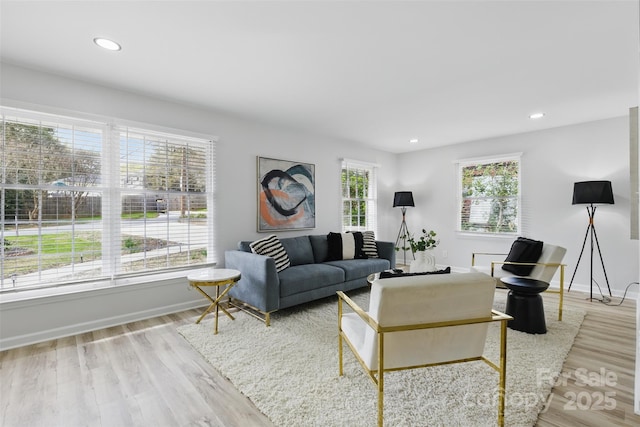 living area with baseboards, wood finished floors, and recessed lighting