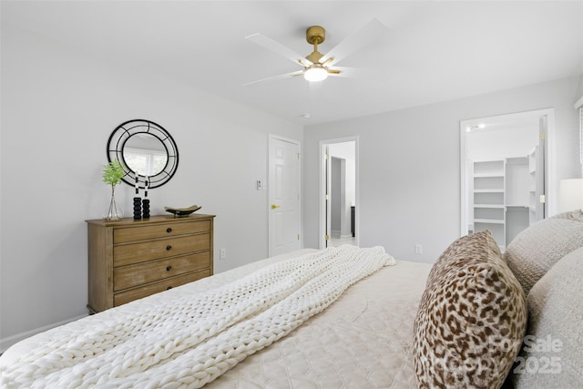 bedroom with ceiling fan and a walk in closet