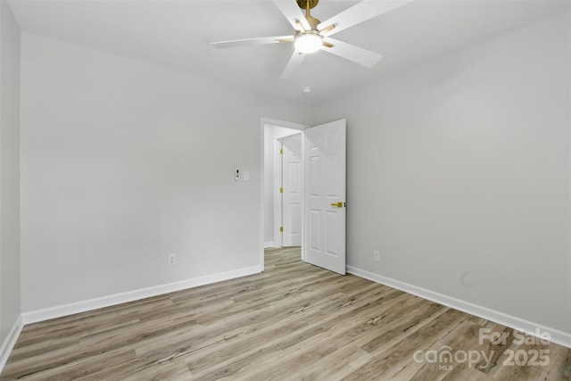 unfurnished room with baseboards, wood finished floors, and a ceiling fan