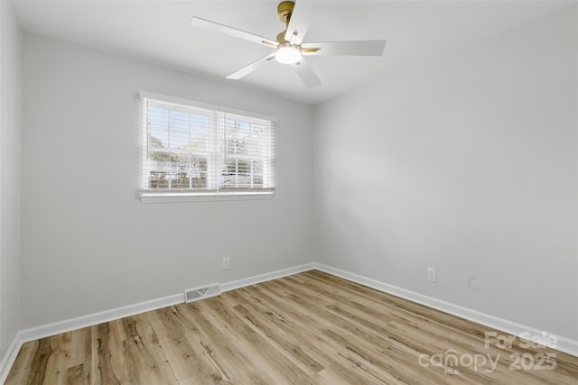 empty room featuring wood finished floors, baseboards, ceiling fan, and visible vents