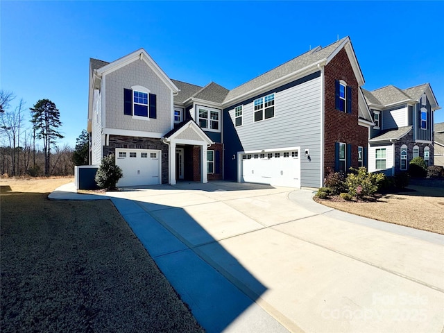 view of front facade featuring a garage, driveway, and stone siding