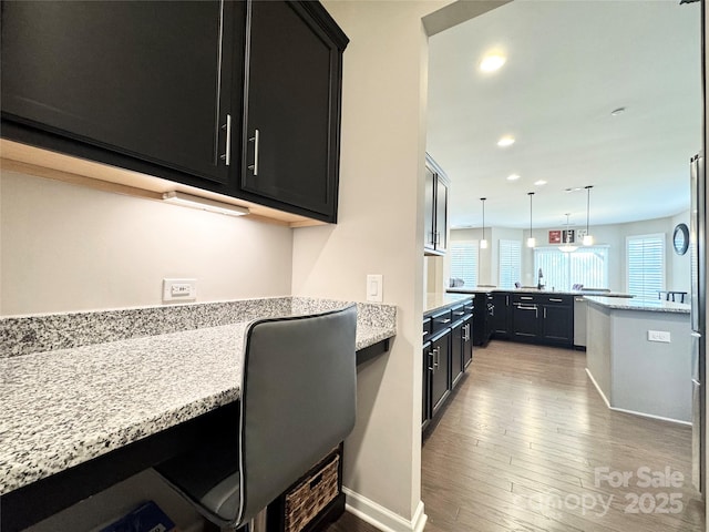 kitchen featuring hardwood / wood-style floors, built in desk, dark cabinets, and recessed lighting