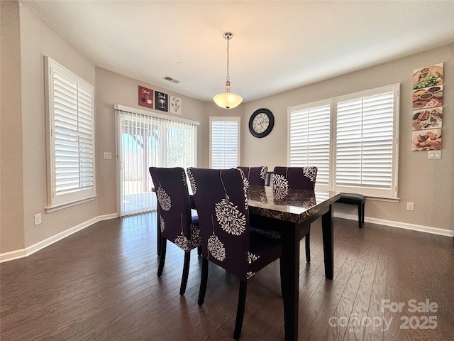 dining space featuring dark wood-type flooring, visible vents, and baseboards