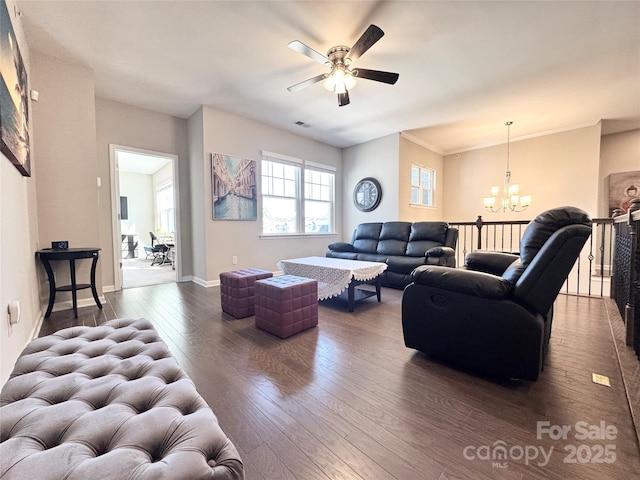 living area with crown molding, ceiling fan with notable chandelier, wood-type flooring, and baseboards