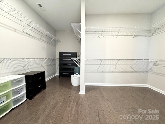 walk in closet with dark wood-style flooring and visible vents