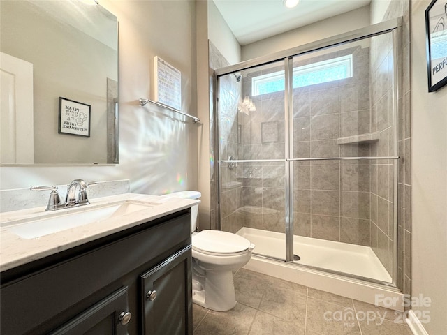 bathroom featuring toilet, a stall shower, tile patterned flooring, and vanity