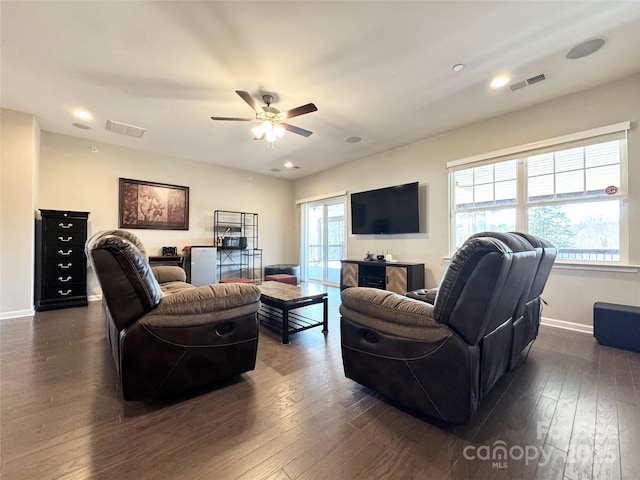 living room with baseboards, visible vents, and dark wood finished floors