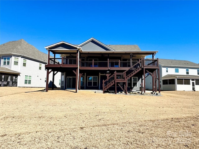 rear view of house with a sunroom, stairway, and a deck