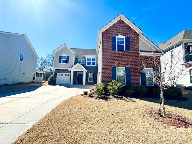 traditional home with an attached garage, a front yard, concrete driveway, and brick siding