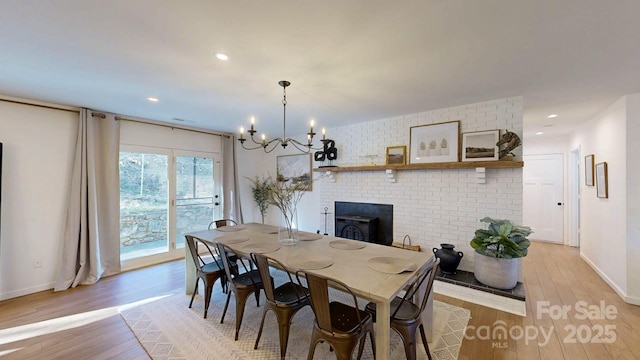 dining room with light wood-style floors, recessed lighting, a notable chandelier, and baseboards