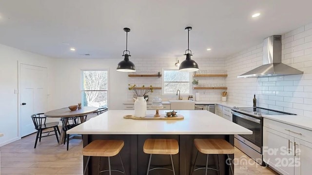 kitchen featuring open shelves, light countertops, electric range, white cabinets, and wall chimney range hood